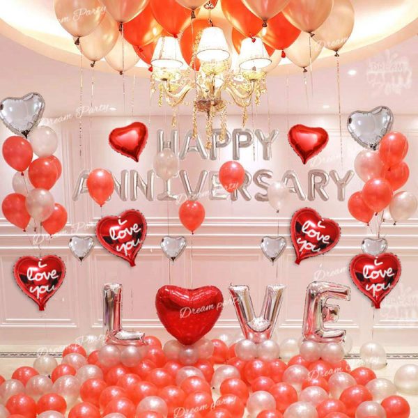 Happy Anniversary decoration set featuring 'Happy Anniversary' foil balloons, red LOVE alphabet balloons, heart-shaped foil balloons, romantic red fairy lights, and latex balloons for a special celebration.