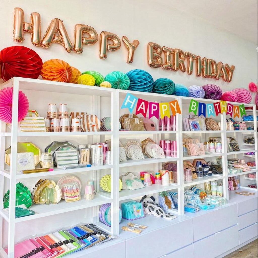 Birthday & Party Decorations featuring colorful balloons, streamers, a vibrant ‘Happy Birthday’ banner, and a beautifully arranged cake table with candles and floral accents